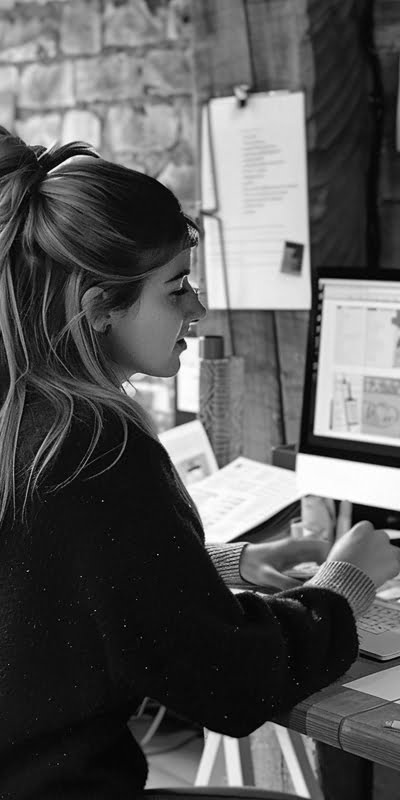 A graphic designer at Obsidian Atlas helping a client with design work.